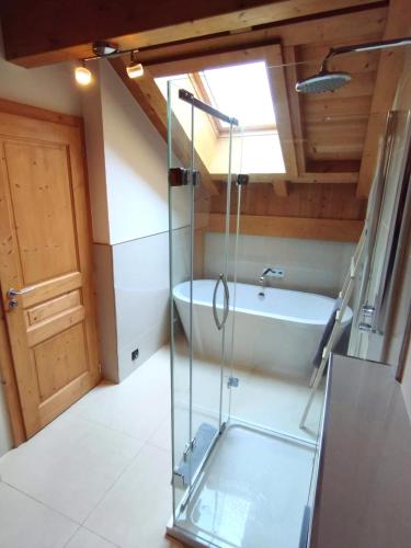 une salle de bain avec une douche en verre et une baignoire dans l'établissement 8-Person Chalet with Hot Tub in Portes du Soleil, à Montriond