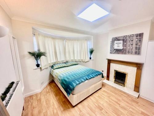 a bedroom with a bed and a fireplace at 5 Bedroom house in DA7 in Erith