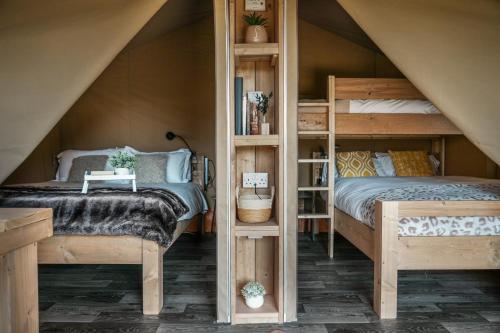 a bedroom with two bunk beds and a staircase at Glamping at Macdonald's Farm in Saint Ervan