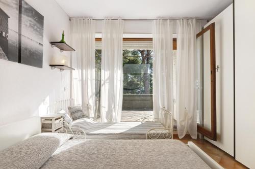 1 dormitorio con una ventana con cortinas blancas en Belvedere su Spotorno, en Bergeggi