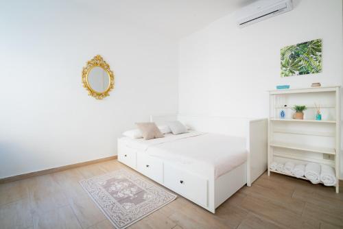 a white bedroom with a bed and a mirror at APT per coppie nel cuore di Desenzano CASTELLO in Desenzano del Garda