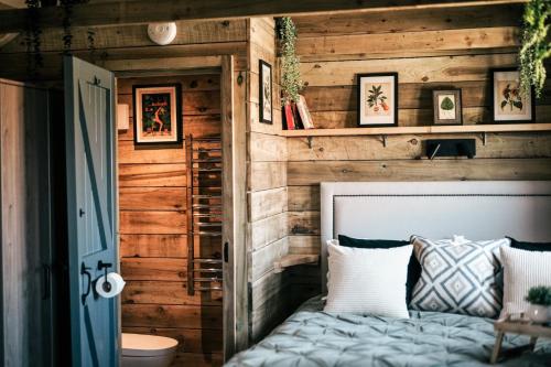 a bedroom with a wooden wall with a bed at The Potting Barn in Saint Ervan