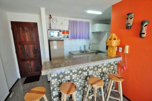 a kitchen with a counter with stools in it at Apartamento na Praia de Iracema, Meireles. in Fortaleza