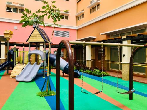 a playground in a building with a slide and swings at JFam Suites - Studio and 1Bedroom Units! in Biñan