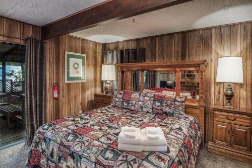 um quarto com uma cama grande e paredes de madeira em Knott Inn em Ruidoso
