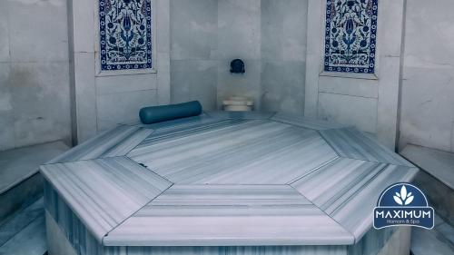 ein großes Bett in einem Zimmer mit einem blauen Stuhl in der Unterkunft Maximum hamam Spa in Kusadası