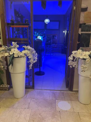 two white vases with flowers in front of a door at Maximum hamam Spa in Kusadası