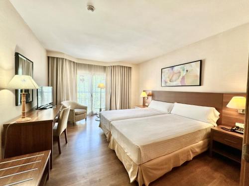 Habitación de hotel con cama grande y escritorio. en Aparto-Hotel Rosales en Madrid