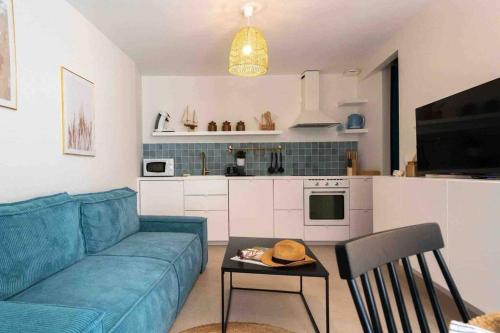 un salon avec un canapé bleu et une table dans l'établissement Appartement T2 la perle bleue, à Agde