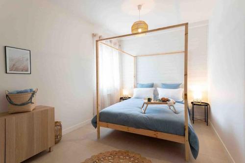 um quarto com uma cama de dossel e uma mesa em Appartement T2 la perle bleue em Agde