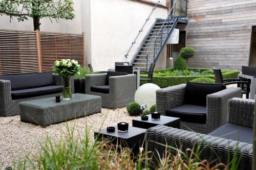 a patio with wicker chairs and tables and stairs at Flanders Hotel in Bruges