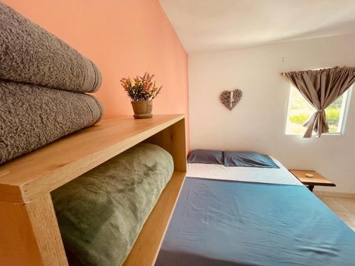 um pequeno quarto com uma cama e uma janela em Finca hotel casa rosada em Tuluá