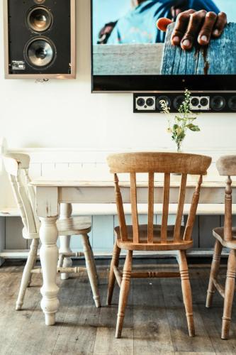 a dining room with a white table and chairs at The Potting Barn in Saint Ervan