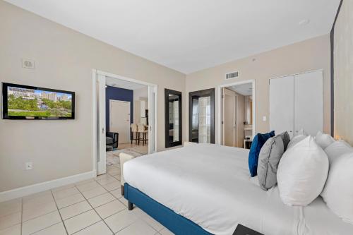 a bedroom with a large white bed and a flat screen tv at The Sagamore Hotel South Beach in Miami Beach