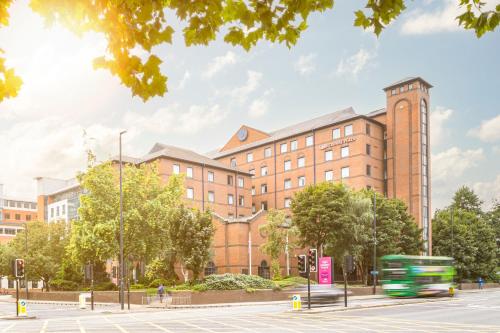 a large brick building with a bus in front of it at Crowne Plaza Leeds by IHG in Leeds