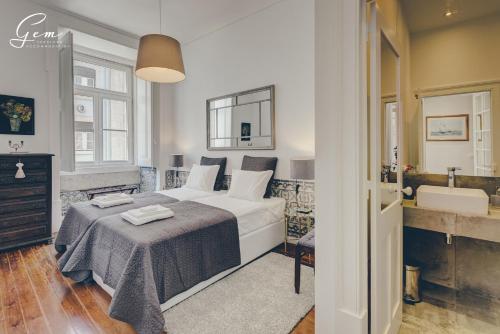 a bedroom with a large bed and a bathroom at Madalena City Center in Lisbon