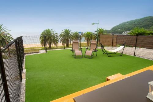 a patio with a lawn with chairs and a hammock at Setouchi Island Stays Suo Oshima in Suo Oshima