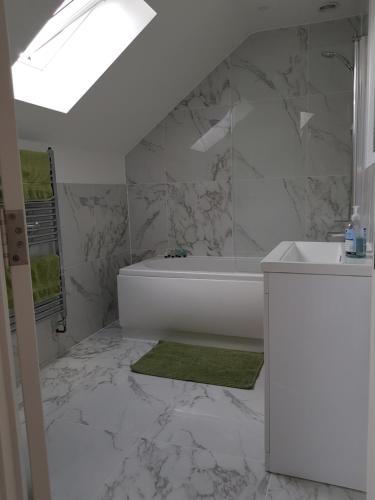 a bathroom with a white tub and a sink at Luxury Holiday Home in St. Leonards
