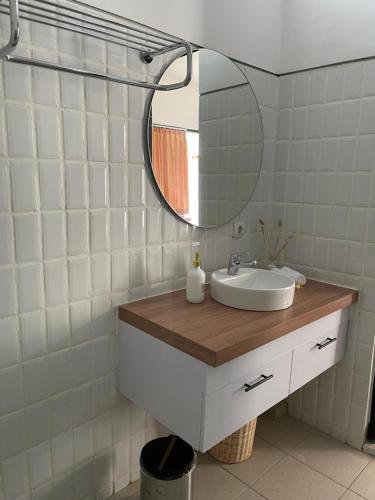 ein Bad mit einem Waschbecken und einem Spiegel in der Unterkunft Aroom Homestay in Kerobokan