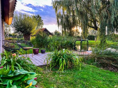 a garden with two chairs and a table and trees at B&B Leonie in Alveringem