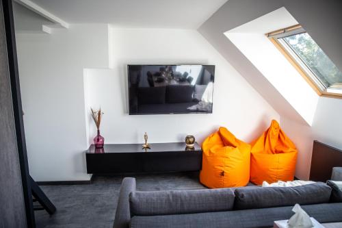 a living room with a couch and two orange pillows at Bienvenue dans l'ambre 2 à 7 couchages in Cholonge