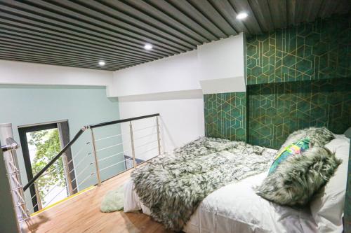 een slaapkamer met een bed en een groene muur bij A103 Cosy City Loft in Coventry