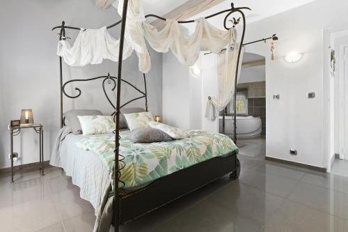 ein Schlafzimmer mit einem Himmelbett mit Baldachin in der Unterkunft Maison au Soleil d'Azur in Fréjus