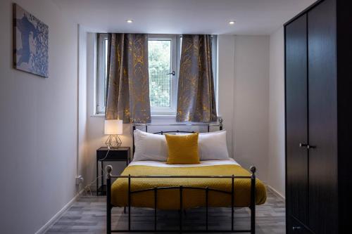 Remarkable 3-Bed Apartment in London في لندن: غرفة نوم بسرير اصفر مع نافذة