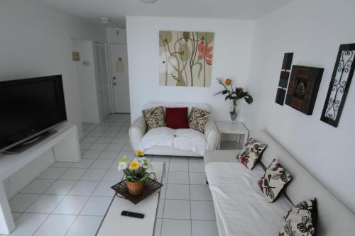 a white living room with a couch and a tv at Castle B6 in Miami Beach