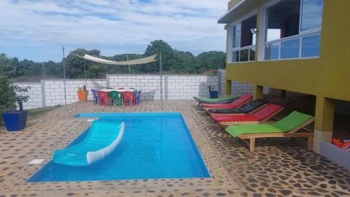 a swimming pool with colorful chairs at CHEZ ALYSSA in Nosy Be