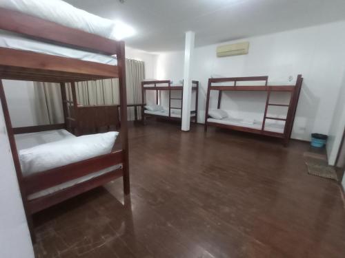 Citywalk Hotel في دوماغيتي: سريرين بطابقين في غرفة مع أرضية خشبية