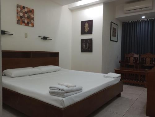 Citywalk Hotel في دوماغيتي: غرفة نوم عليها سرير وفوط
