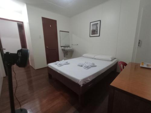 a small room with a bed with a mirror at Citywalk Hotel in Dumaguete