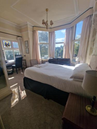 a bedroom with a large bed with a large window at Regency Hotel in Leicester