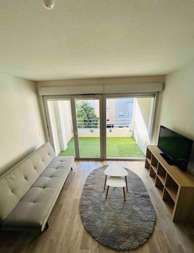 sala de estar con sofá y mesa en Appartement T2 + parking privatif - Centre ville, en Bayona