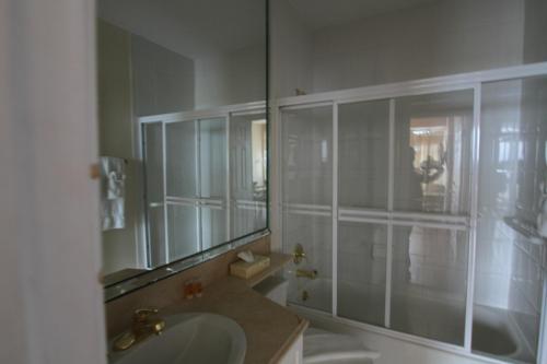 een badkamer met wastafel en douche met spiegel bij Castle PH15 Spacious Penthouse with Balcony, Beach Access, Pool, Tennis, Free Parking in Miami Beach