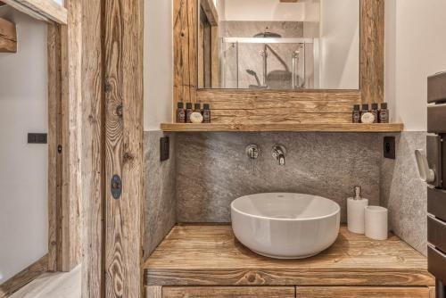 une salle de bain avec un lavabo blanc et un miroir dans l'établissement Chalet BelleVue, à Chamonix-Mont-Blanc