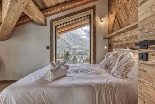 une chambre avec un grand lit blanc avec une fenêtre dans l'établissement Chalet BelleVue, à Chamonix-Mont-Blanc