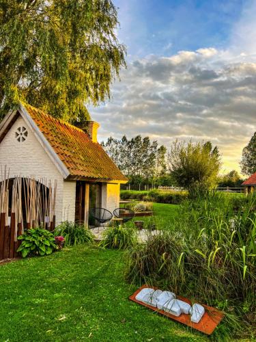 a house in a yard with a yard at B&B Leonie in Alveringem