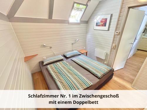 a small bedroom with a bed in a room at Mein-Seepark, Ferienhaus Heike in Kirchheim