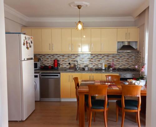 cocina con mesa y nevera blanca en Şencan House, 