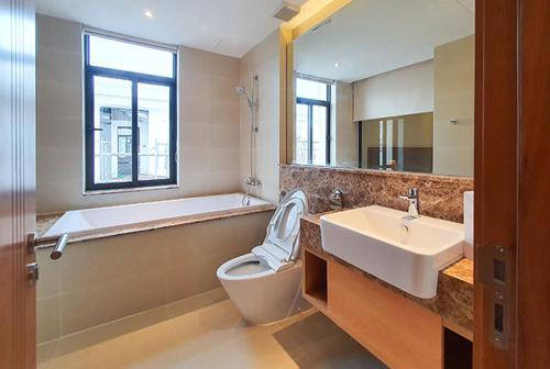 y baño con bañera, aseo y lavamanos. en Luxury villa trong Whyndham garden Cam Ranh en Nha Trang