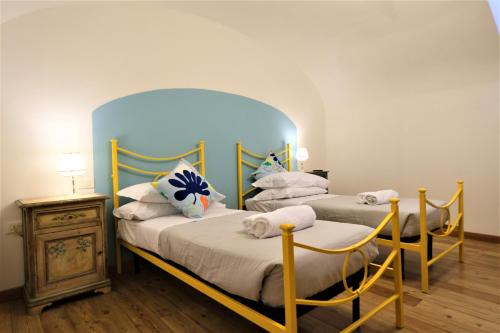 2 Betten in einem Zimmer mit blauem Kopfteil in der Unterkunft Wine Apartments Florence Nebbiolo in Florenz