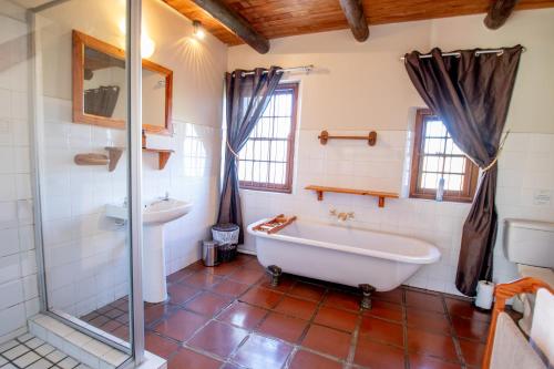 La salle de bains est pourvue d'une baignoire, d'une douche et d'un lavabo. dans l'établissement Manley Wine Estate, à Tulbagh