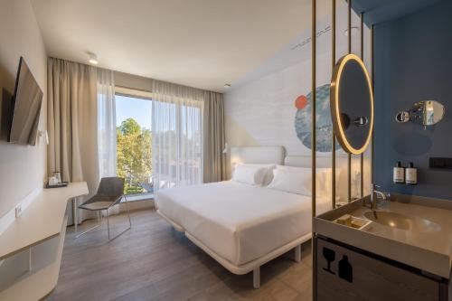 a bedroom with a bed and a sink and a mirror at Occidental Ljubljana in Ljubljana