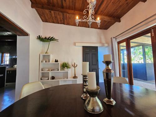 a dining room with a table and a chandelier at The Retreat Swellendam in Swellendam
