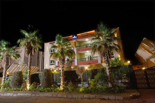 a building with palm trees in front of it at The Villa 604 Powered by look in Cairo