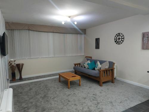 2 large bedroom apartment- WIFI & Parking في فليتوود: غرفة معيشة مع أريكة وطاولة