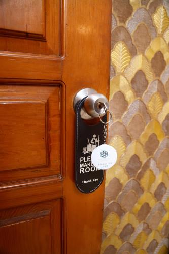 a door tag on a wooden door with a knob at Waypoint Hotel in Karachi