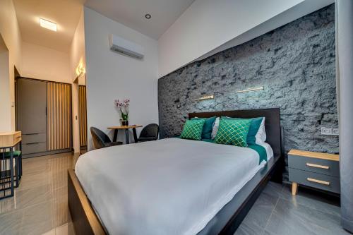 a bedroom with a large bed and a stone wall at Komorowski Luxury Guest Rooms in Kraków